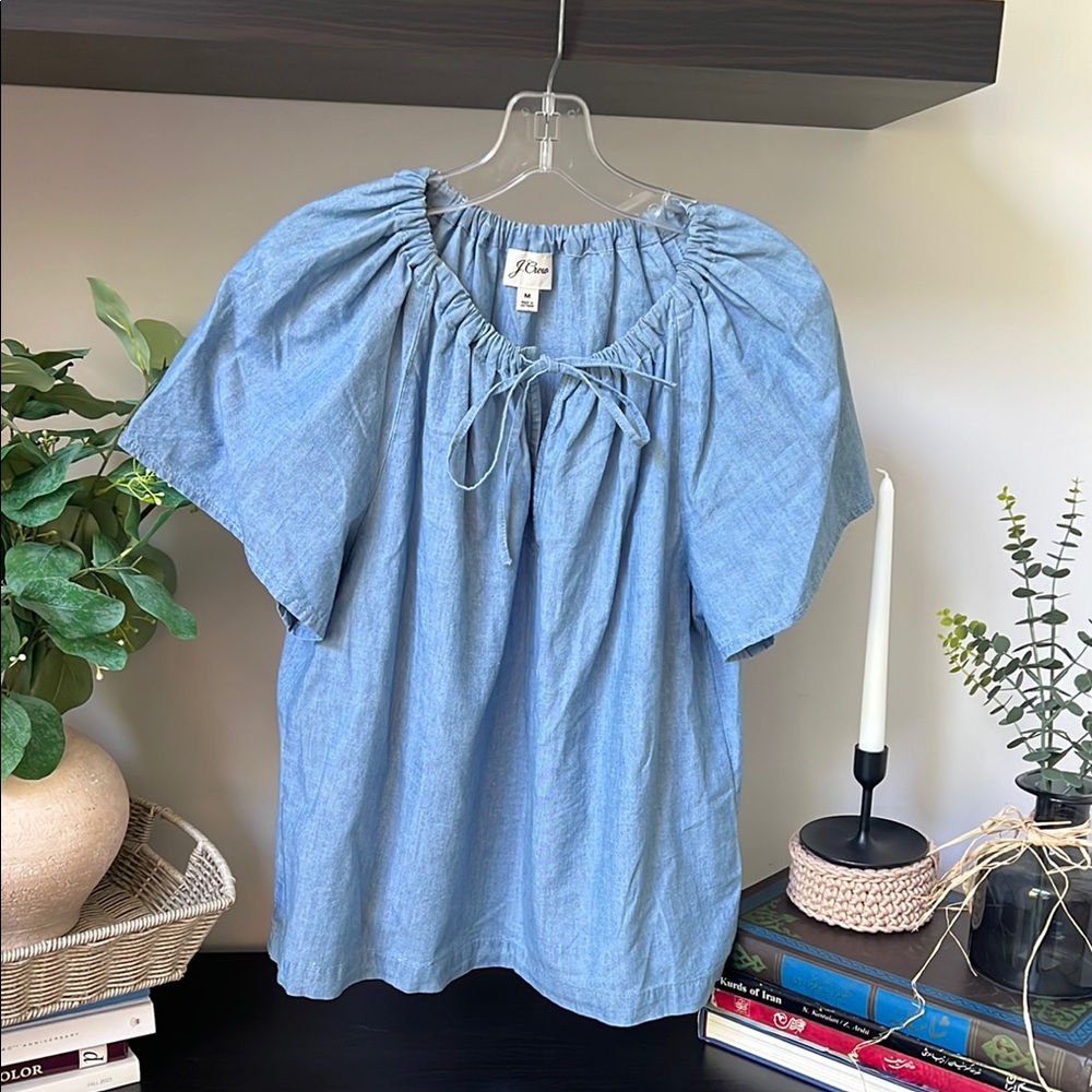 A J.Crew Chambray Flowy Blue Top in size M.  This top has short sleeves.